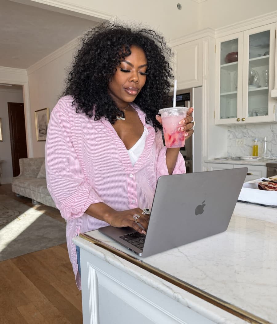 Zuleema on her laptop at the kitchen counter, casual and relaxed